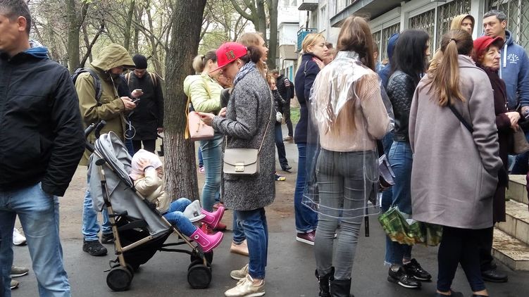 Очереди на смену места голосования в Шевченковском районе Киева людям приходится ждать под дождем на улице. Фото: Страна
