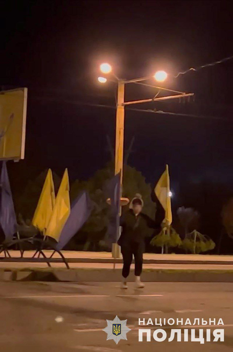 На центральном проспекте Запорожья девушка сняла флаги с украинской символикой